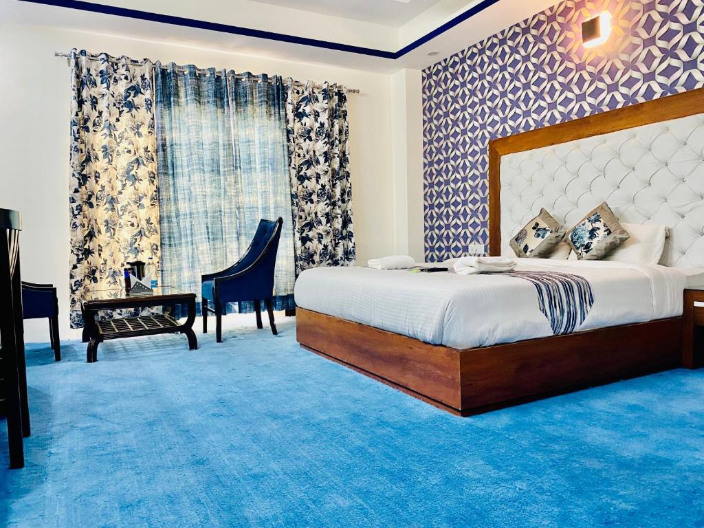 a bedroom with a large bed and a blue carpet at Radiance Regency Resort Chail in Chail