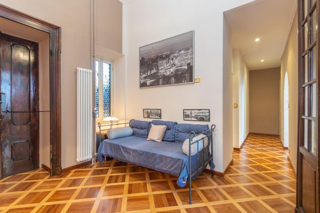 salon z niebieską kanapą i drewnianą podłogą w obiekcie Liberty Suite w Turynie
