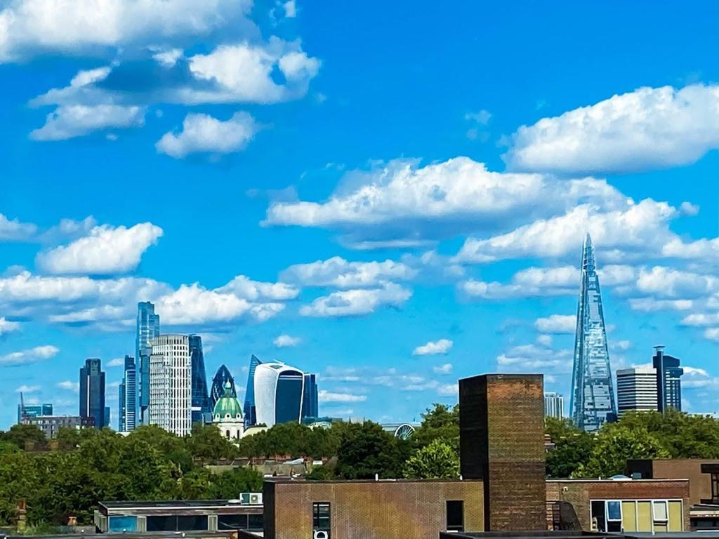 a city panorama with a blue sky and clouds w obiekcie Spacious Room with City Skyline Views close to London Eye w Londynie