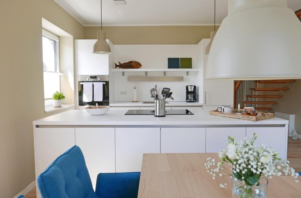 a kitchen with white cabinets and a wooden table at Borbyer Perle in Eckernförde