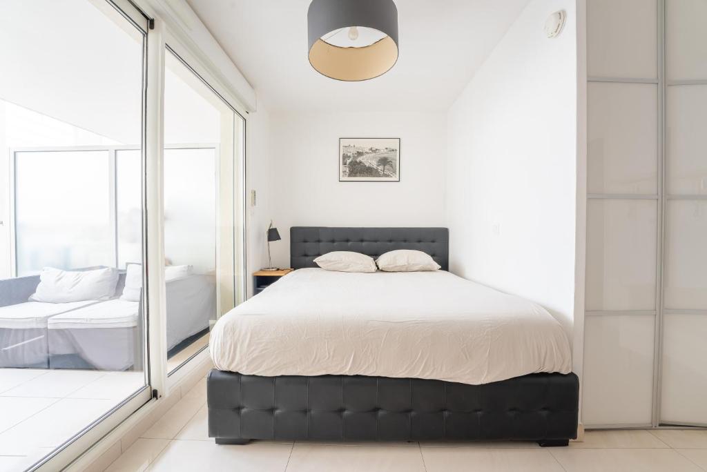 une chambre avec un grand lit et un miroir dans l'établissement Joli studio centre Cannes, à Cannes