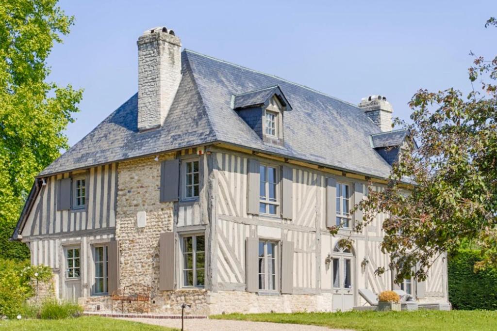 una vieja casa de piedra con techo de gambrel en Le Manoir De St Martin - 4 Ch - Deauville en Saint-Martin-aux-Chartrains
