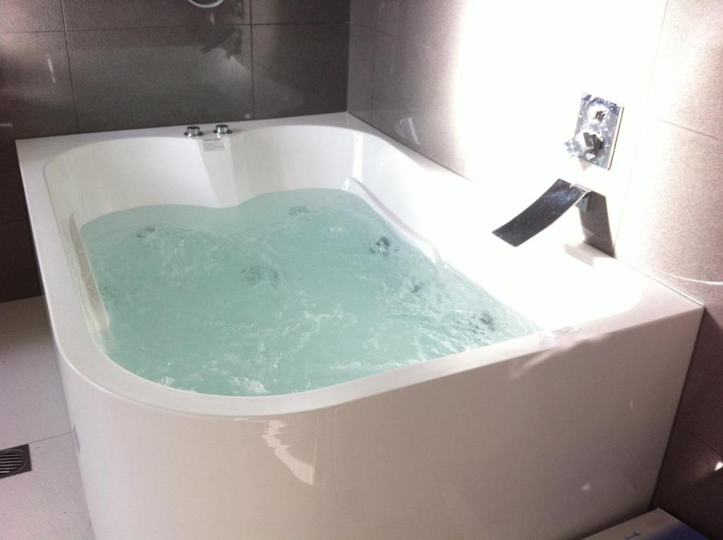 a bath tub filled with blue water in the shape of a heart at Sea Salt Bnb in Rosebud