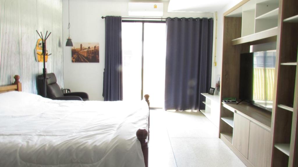 een slaapkamer met een bed en een glazen schuifdeur bij Reconnecting in Chiang Mai