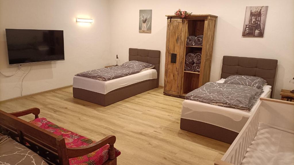 two beds in a room with a flat screen tv at Casa Verde Sinnerthal in Neunkirchen