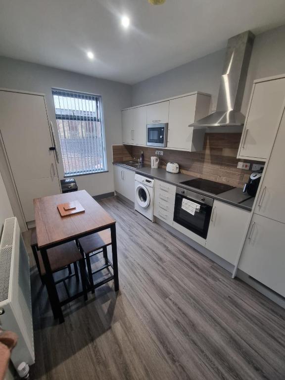 a large kitchen with a table and a tableablish at Sussex Apartments 26B in Grimsby