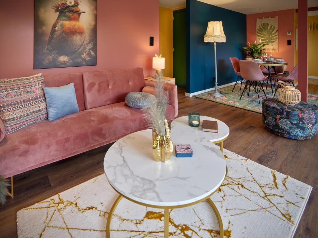 uma sala de estar com um sofá rosa e uma mesa em Lacuna STILLA em Lanaken