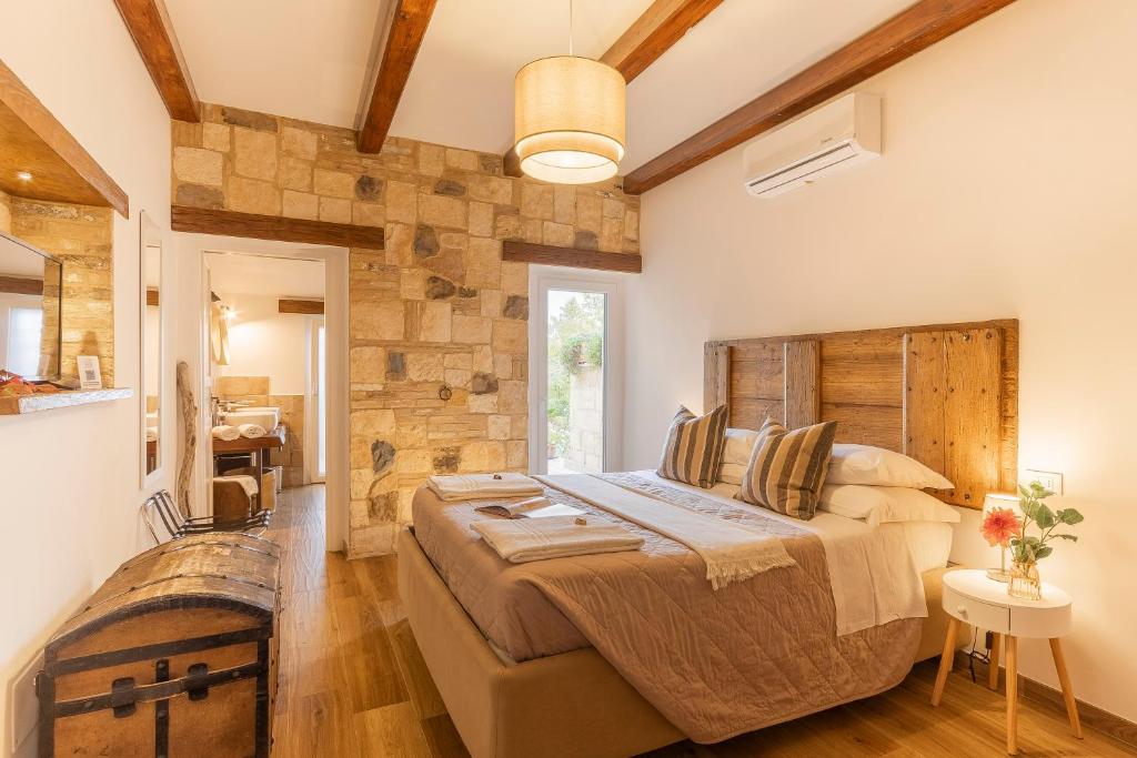 una camera con un grande letto e un muro di pietra di Ginevra Home a Monterosi