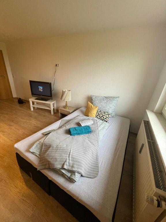 a large bed in a room with a television at Stadtrand Oase Appartement in Spenge