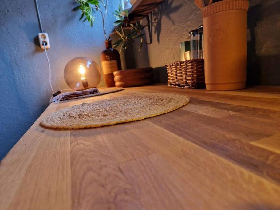 una alfombra en el suelo de madera con una vela encendida en Koselig kjellerleilighet en Bergen