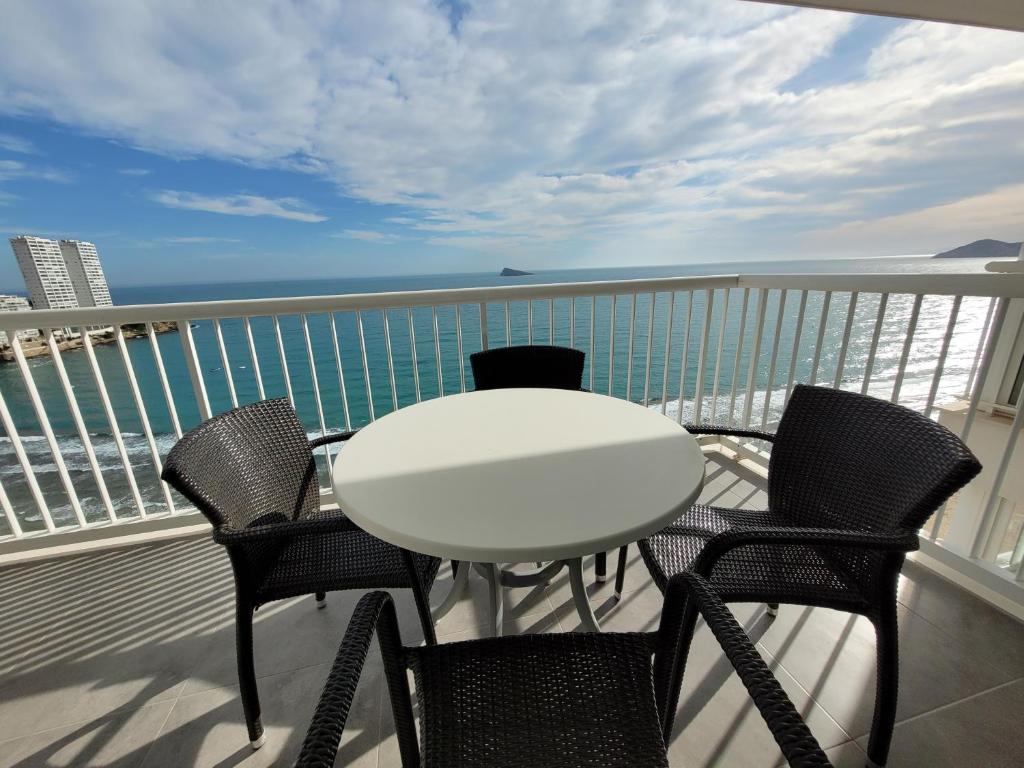 a white table and chairs on a balcony with the ocean at Veracruz-Fincas Benidorm in Benidorm