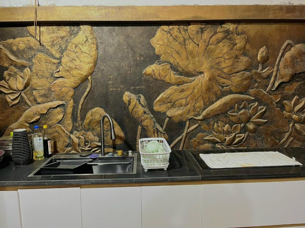 um balcão de cozinha com um lavatório e um mural de flores em The Memory Villa - Mộc Châu em Mộc Châu