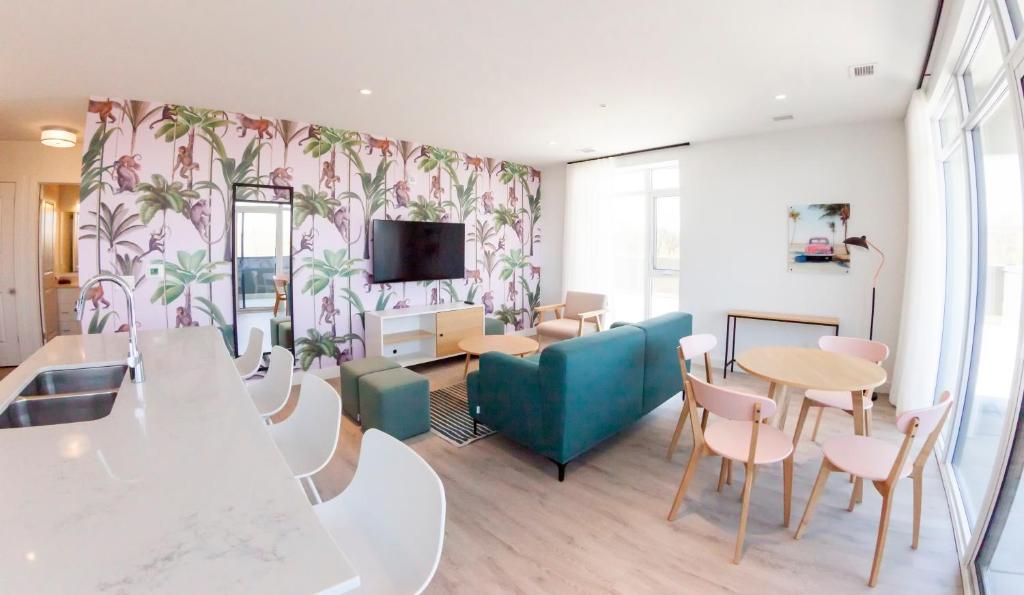 a living room with a table and chairs and a tv at The Laundry Rooms Gaslight Cambridge in Cambridge