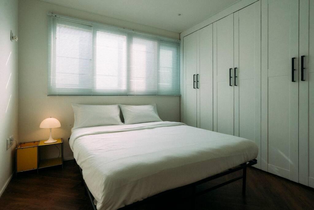 a bedroom with a large white bed and a window at Leo's house NYC in Daegu in Daegu