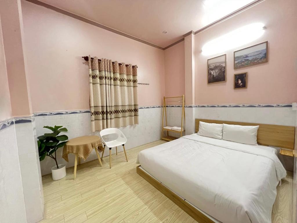 ARYE guest house في Ấp Lợi Ðủ: غرفة نوم بسرير وطاولة وكرسي