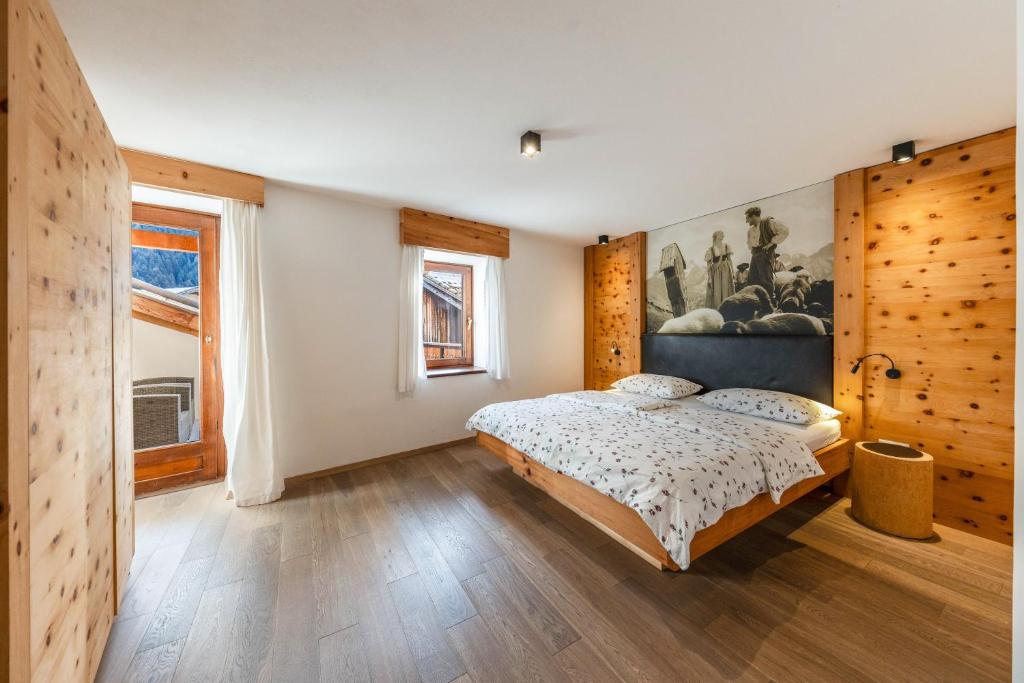 1 dormitorio con 1 cama y una pintura en la pared en Naturoase Stegerhof Apt Iris, en Trodena