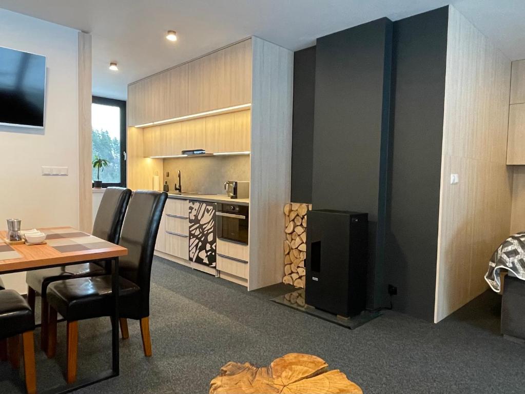 a living room with a dining table and a kitchen at Apartmán A29-2, Hrabovo, Ružomberok in Ružomberok