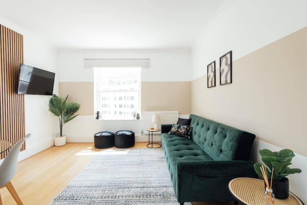 a living room with a green couch and a rug at Stylish Central Kings Cross 2 Bedroom Flat in London