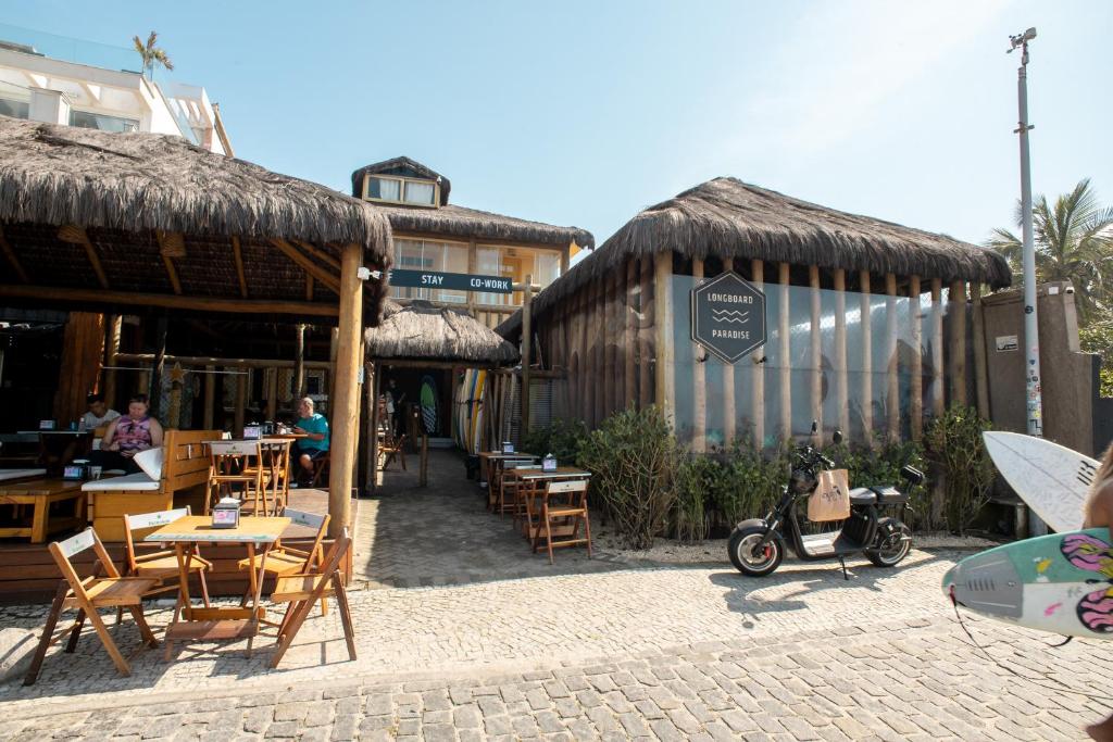 里約熱內盧的住宿－Longboard Paradise Surf Club，配有桌椅的餐厅以及停放在户外的摩托车