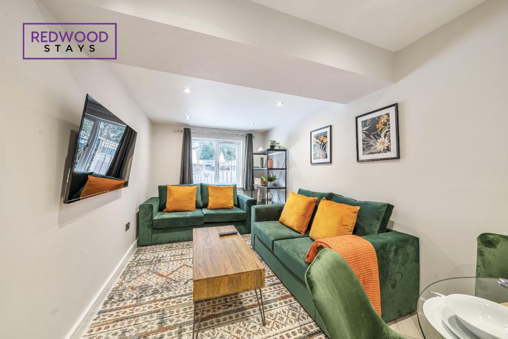 a living room with two green couches and a table at HUGE 5 Bed 3 Bath House For Contractors & Families, X2 FREE PARKING, FREE WiFi & Netflix By REDWOOD STAYS in Farnborough