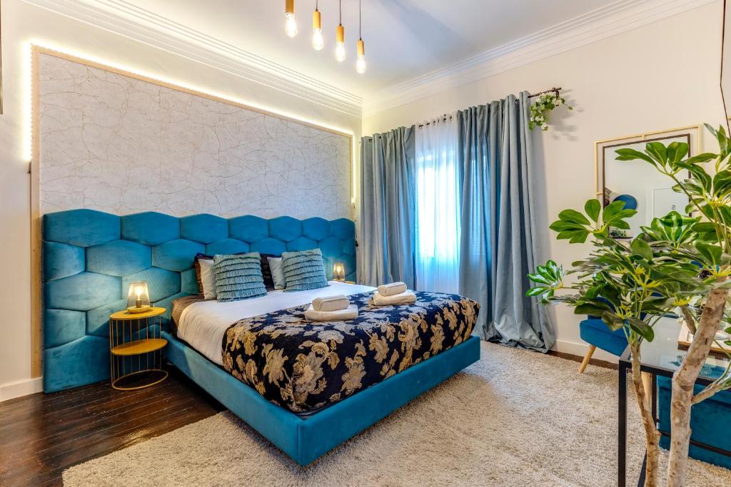 um quarto azul com uma cama grande e uma cabeceira azul em Quiet View Rooms em Porto