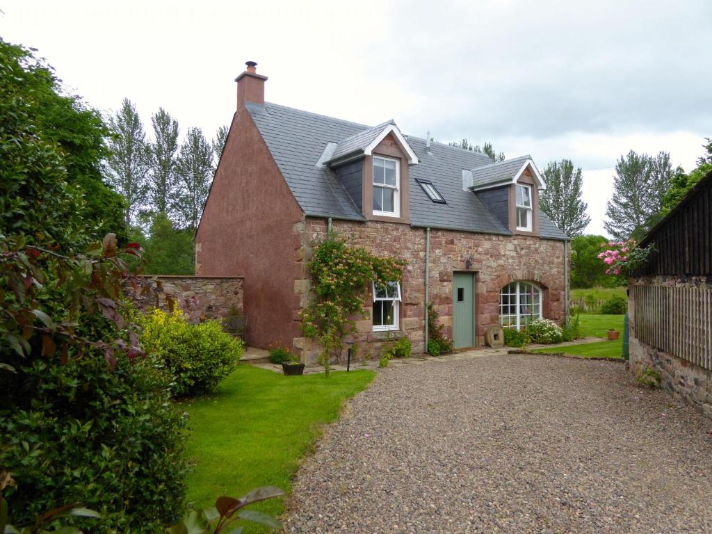 a large brick house with a gravel driveway at Old Mill Cottage in Kelso
