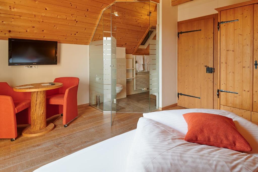 Schlafzimmer mit einem Bett, einem Tisch und einem TV in der Unterkunft Winzerzimmer Scharl in Sankt Anna am Aigen