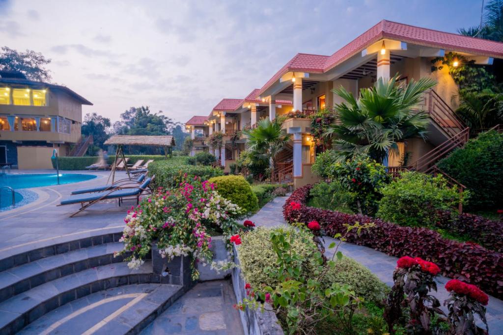 a resort with flowers and a swimming pool at Hotel Jungle Crown in Sauraha