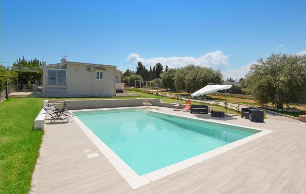 uma piscina num quintal com uma casa em 3 Bedroom Pet Friendly Home In Solarino em Solarino