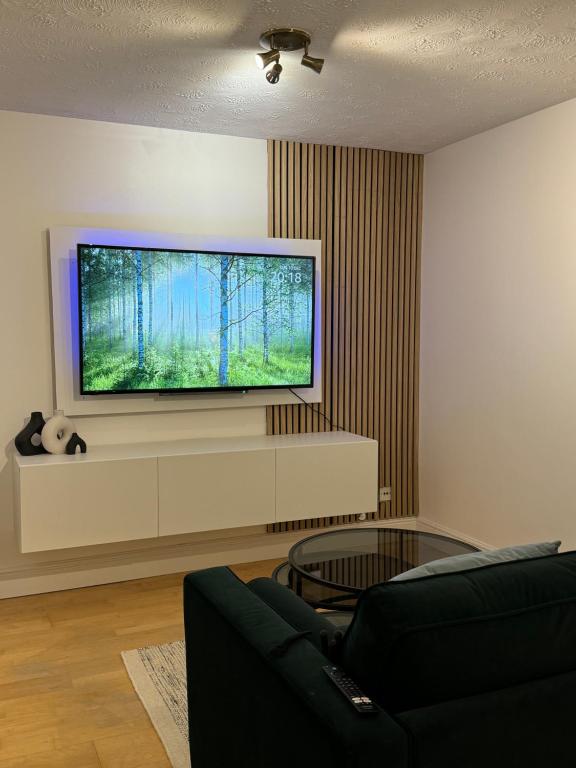 a living room with a flat screen tv on a wall at Cosy 1 Bed, Wembley in London