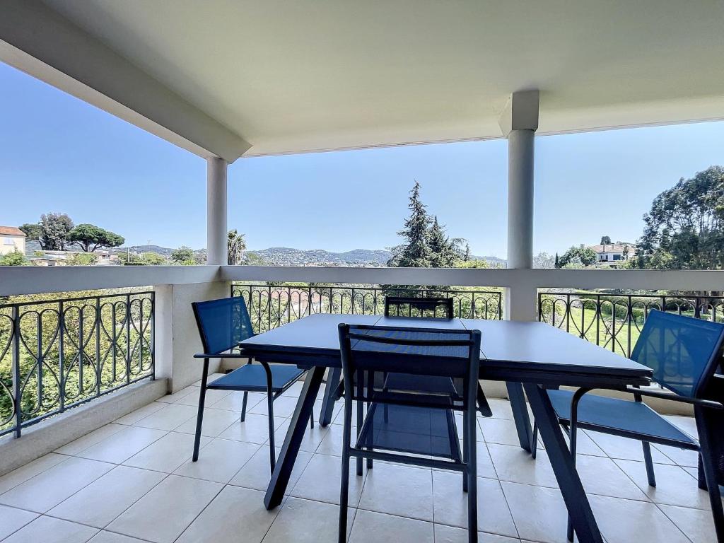 un porche avec une table et des chaises sur un balcon dans l'établissement Cannes - 2 pièces résidence avec parc et piscine, à Cannes