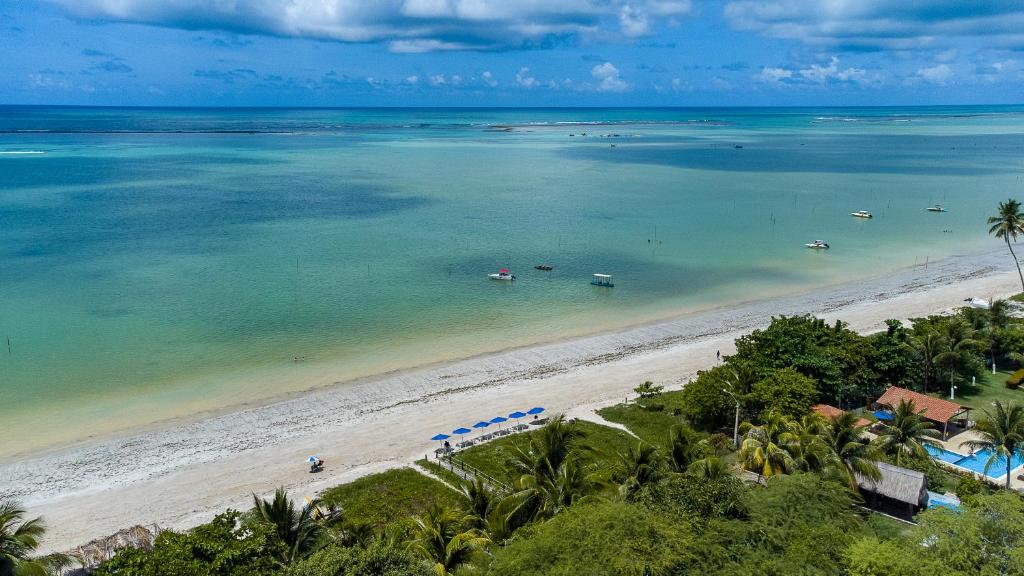 an aerial view of a beach with boats in the water at Pousada Ponta de Mangue in Maragogi