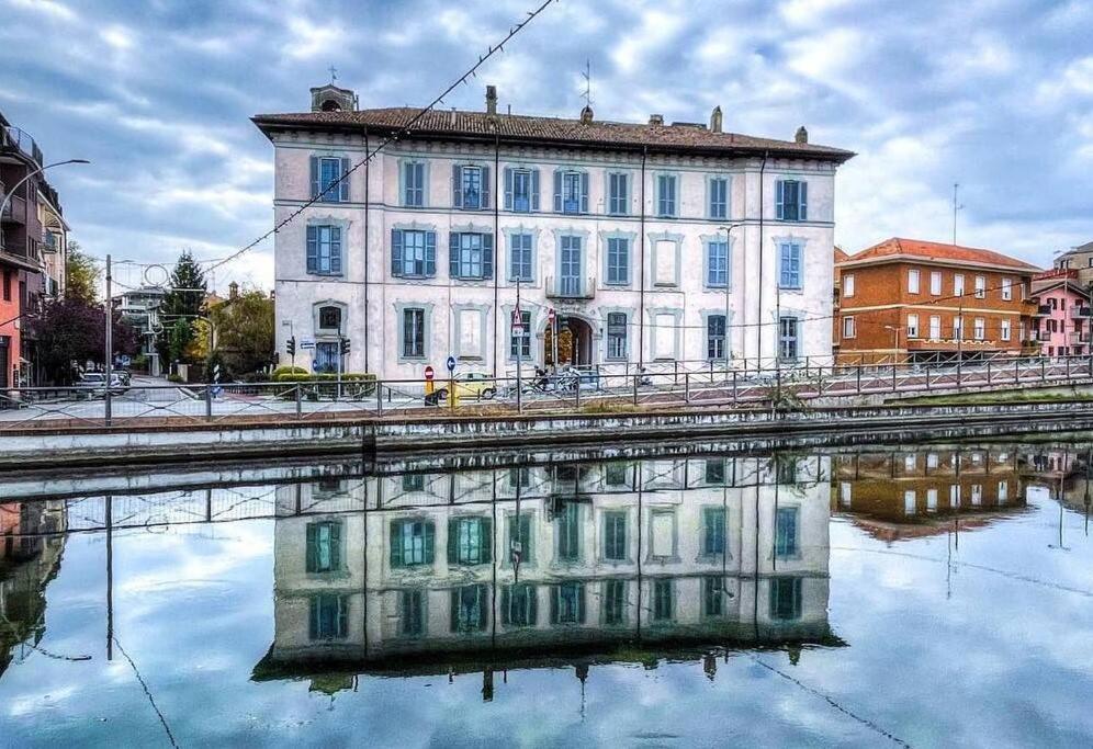 un vecchio edificio con la sua riflessione nell'acqua di Antica dimora sul Naviglio a Gaggiano