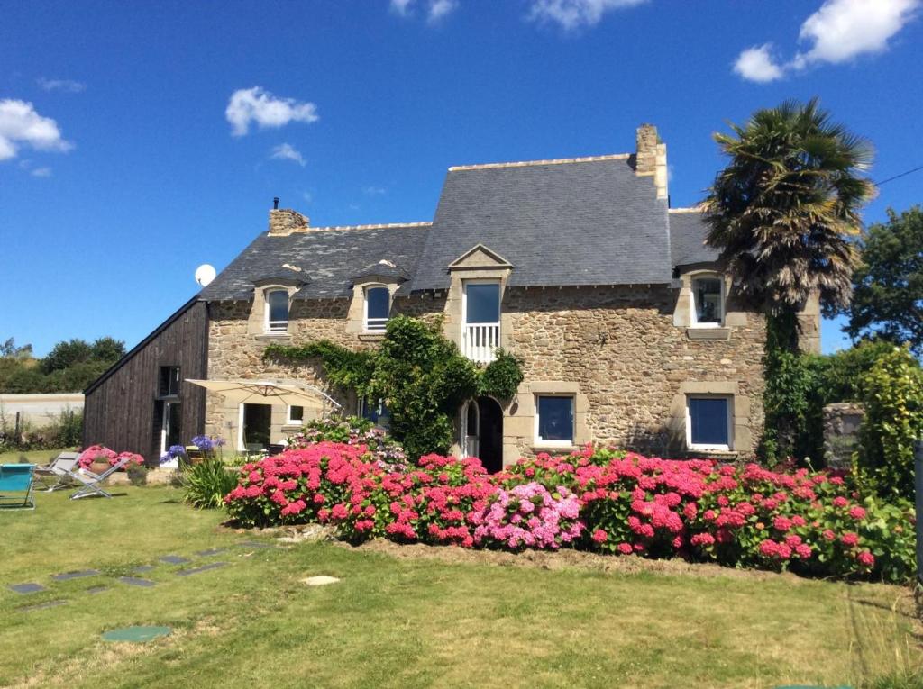 a large stone house with flowers in the yard at La petite salmonais in Saint Malo