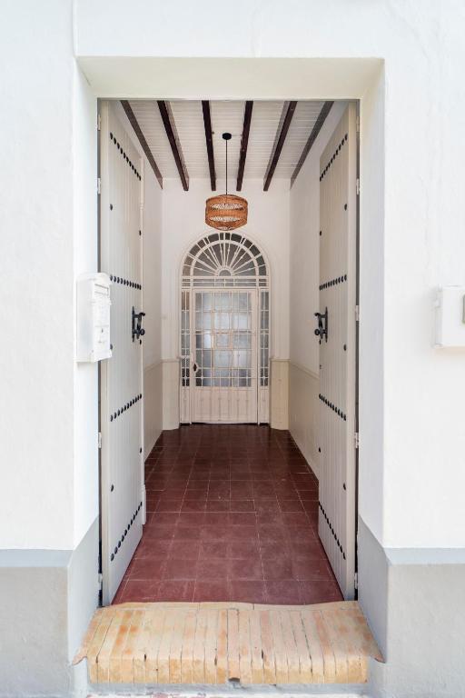 an empty hallway with white doors and a brick floor at La Casa del Convento in Villamanrique de la Condesa