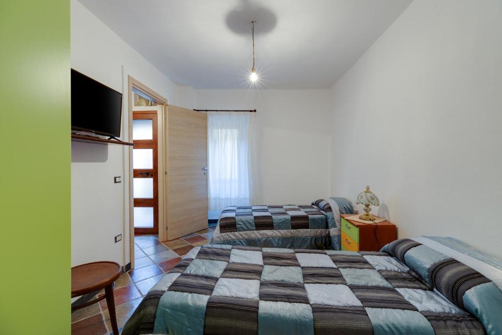 1 dormitorio con 2 camas, sofá y TV en Entu Nou, en Bortigali