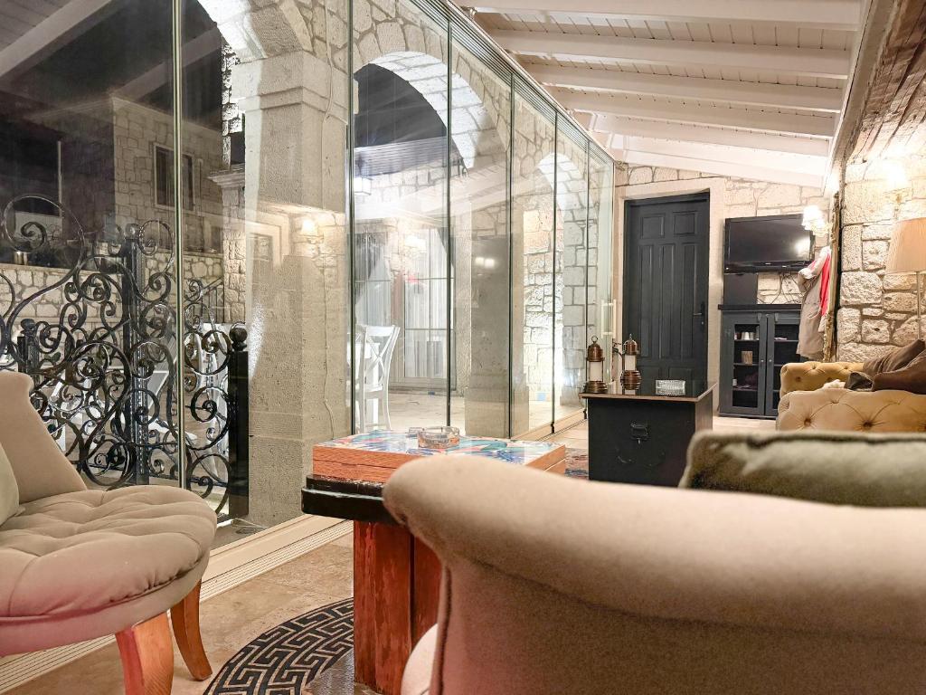 um quarto com uma sala de vidro com uma mesa e cadeiras em Fedora Otel Alaçatı em Alacati