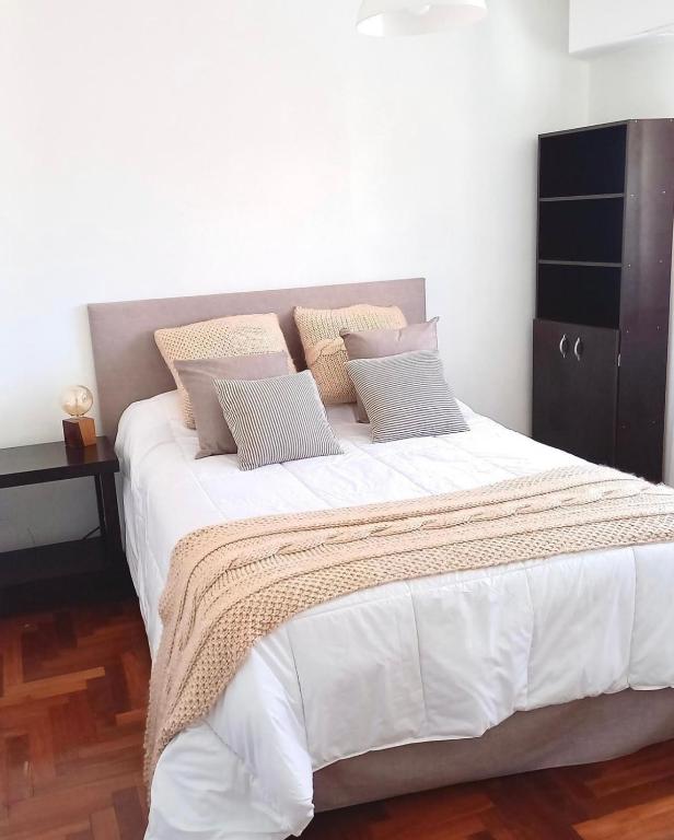 1 dormitorio con 1 cama grande con sábanas y almohadas blancas en Depto de 2 Amb - 4 Pax - B San José en Mar del Plata