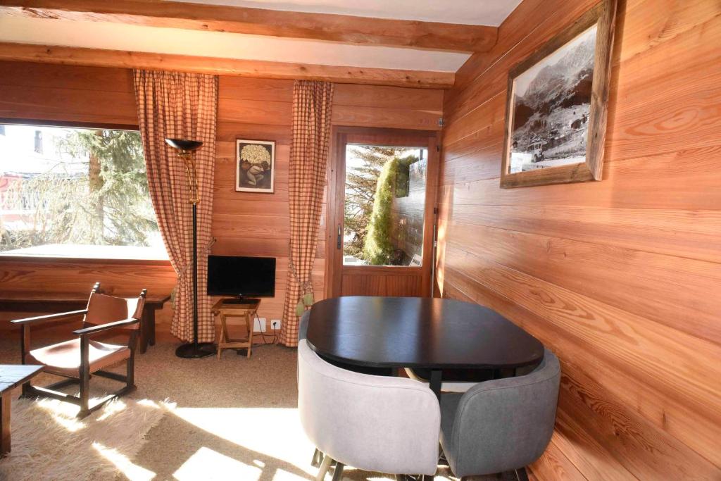 a room with a table and chairs and a television at Verbier centre, 2 chambres proche de tout. in Verbier