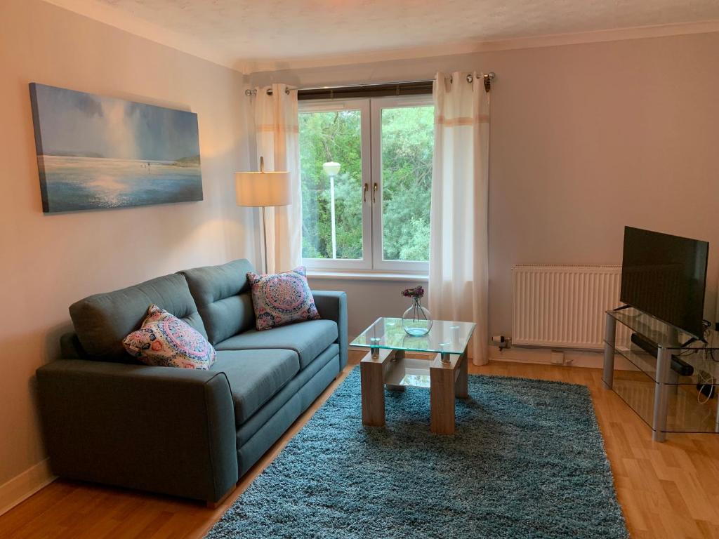 - un salon avec un canapé et une table dans l'établissement Modern One Bedroom Apartment, à Lossiemouth