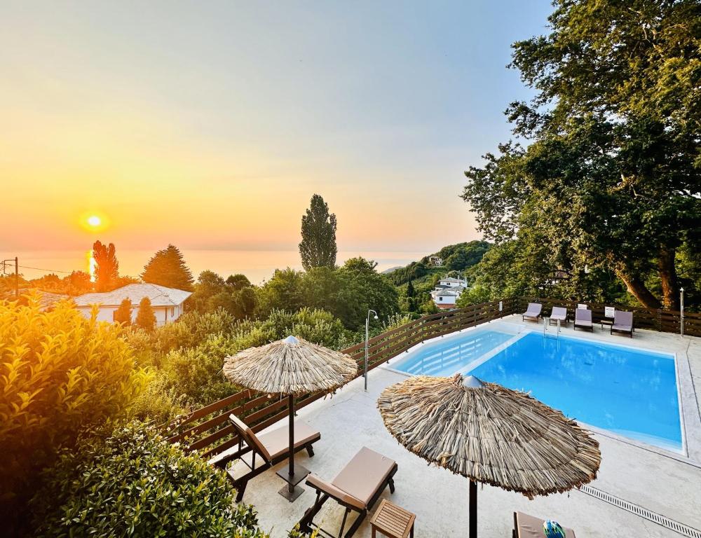 una piscina con 2 sombrillas y sillas y una piscina en Luxury Villa at Pelion- Ruby, en Zagora