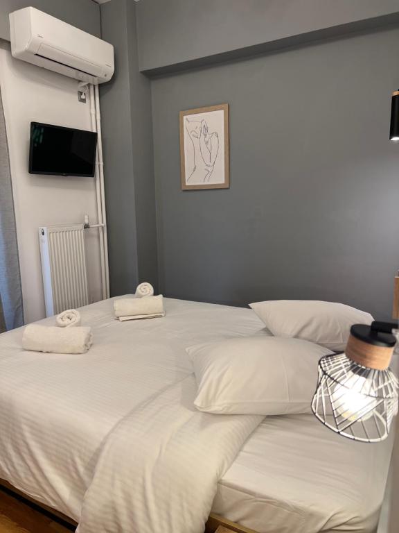 a large white bed with two towels on it at Hotel Nefeli in Volos