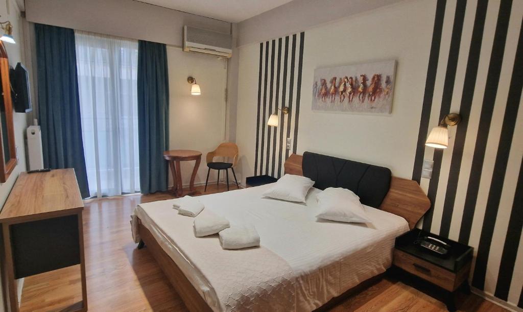 a bedroom with a bed with pillows on it at Hotel Nefeli in Volos