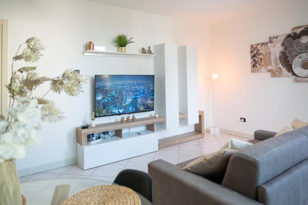 uma sala de estar com um sofá e uma televisão em Desenzanino Lakeside - 1 min from the beach em Desenzano del Garda