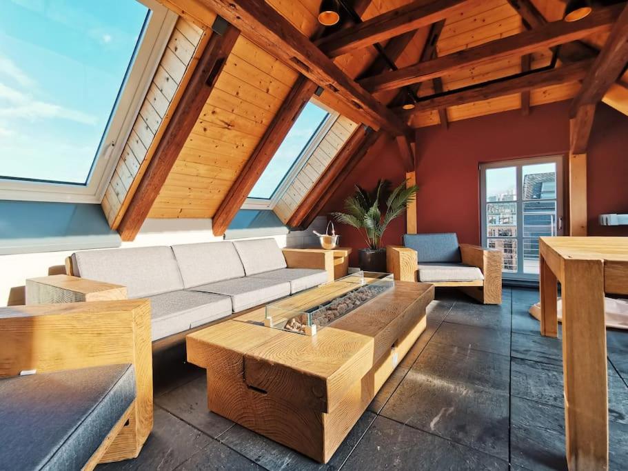 ein Wohnzimmer mit einem Sofa, Tischen und Fenstern in der Unterkunft Luxus Apartment mit Blick über Erfurt im Zentrum in Erfurt