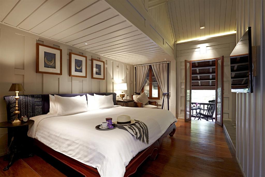 ein Schlafzimmer mit einem großen Bett und einem Tablett darauf in der Unterkunft Burasari Heritage Luang Prabang in Luang Prabang