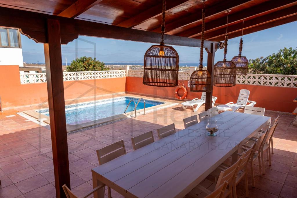 コラレホにあるVilla Atlantic Ocean Private Pool Corralejo By Holidays Homeのパティオ(テーブル、椅子付)、スイミングプールが備わります。