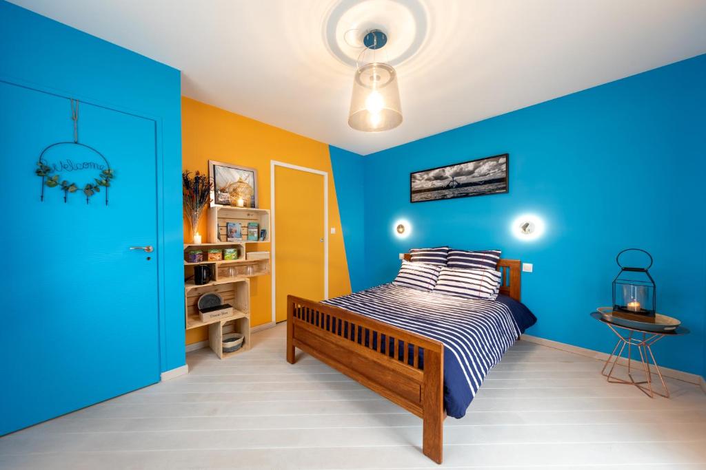 a bedroom with blue and yellow walls and a bed at Bon Accueil in Saint Malo