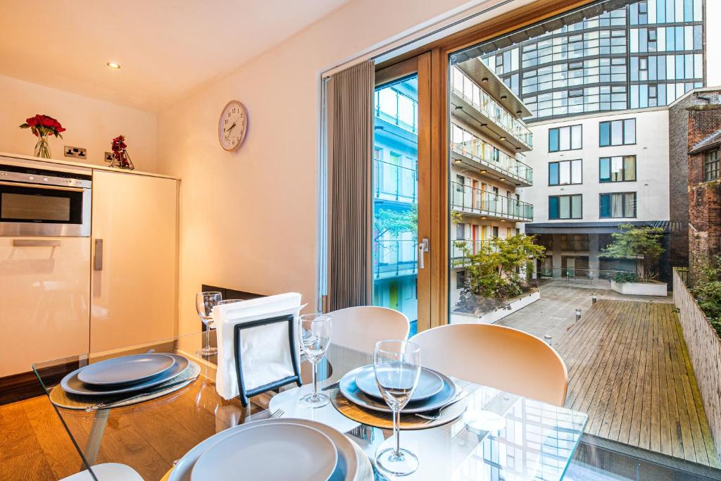 a dining room with a table and chairs and a large window at Stylish 2 Bed City Centre Apartment with Sofa Bed - FREE Parking, Espresso Machine, Netflix, Alexa in Sheffield