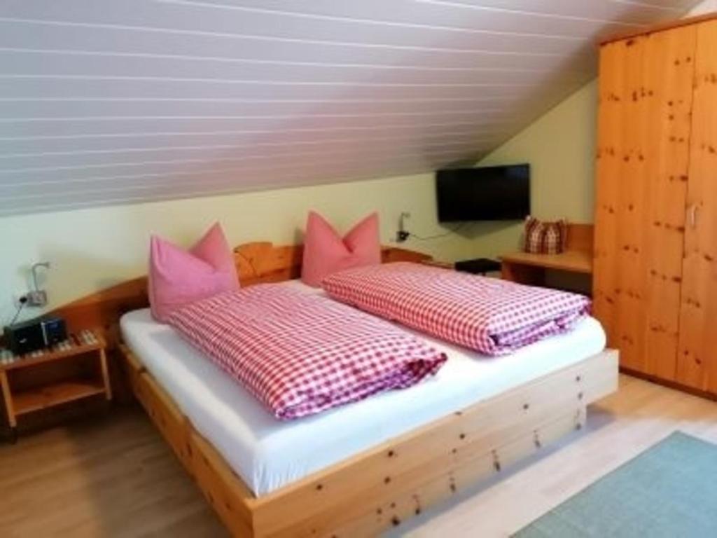 ホプフェラウにあるZimmer Alpseeのベッドルーム1室(ピンクの枕が付いたベッド1台付)